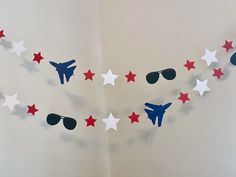 red, white and blue paper stars are strung from the ceiling with sunglasses on them