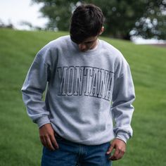 Represent your state pride in style with our Montana Unisex Pullover! Featuring bold, large lettering, this heather grey pullover is the perfect addition to your wardrobe. Show off your love for Montana in a fun and fashionable way. 70/30 Cotton/PolyesterRelaxed FitChest Width: S-20", M-22", L-24", XL-26, 2X-28"Body Length: S-28", M-29", L-30", XL-31" 2X-32" A Montana Scene Original Design. Printed in Montana. All designs are property of The Montana Scene. All rights reserved. Come visit our sto Kids Onesies, Kids Beanies, Grey Pullover, Brand Ambassador, Kids Hats, Kid Tees, Womens Tank, Kids Hoodie, Original Design