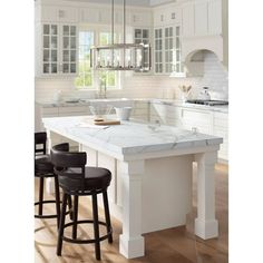 a white kitchen with marble counter tops and stools next to the island in front of it