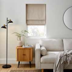 a living room with a couch, lamp and mirror