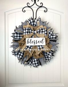 a black and white wreath with the word, blessed on it hanging on a door