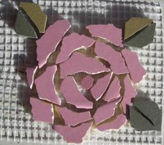 a rose made out of pink and green paper