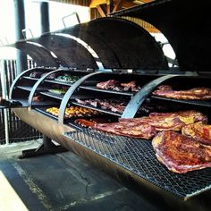 meat is being cooked on the grill in an outdoor restaurant or barbeque area