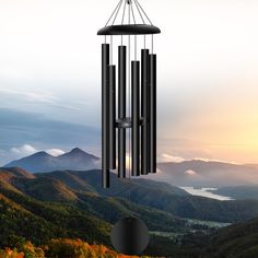 a wind chime hanging from the side of a mountain with mountains in the background