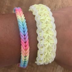 two different colored bracelets are on someone's arm, one is made out of plastic