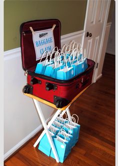 a red suitcase with blue bags in it sitting on top of a wooden floor