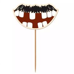 a tooth shaped cake topper on a stick