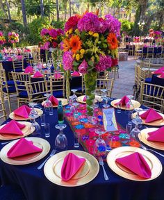 the table is set with pink and yellow napkins