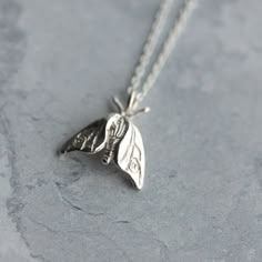 A tiny woodland moth, hand-carved and cast in sterling silver - a perfect gift for nature lovers. Moths are guided by the moon and fly fearlessly towards moonlight; wear this pendant as a symbol of your own bravery and self-belief. This delicate moth pendant hangs on an 18 inch fine silver chain. The pendant is small and delicate, dimensions are 14mm x 13mm. It can be worn alone or layered with other jewellery. Also available as a larger silver hawk moth necklace, as pictured: https://www.etsy.c Moth Pendant, Moth Necklace, Woodland Jewelry, Dope Jewelry, Rose Jewelry, Funky Jewelry, Gifts For Nature Lovers, Dream Jewelry, Pretty Jewellery