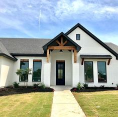 a white house with black trim and wood accents