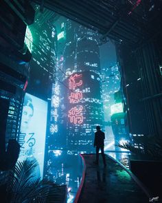 a man standing in the middle of a city at night with neon lights on buildings