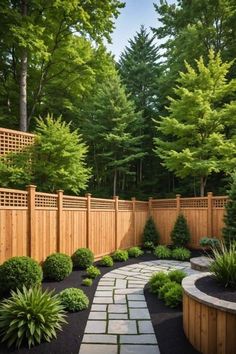 a wooden fence and stone path in the middle of a yard with trees, shrubs and bushes