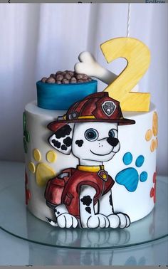 a birthday cake decorated with a fireman's dog and number 2 on it