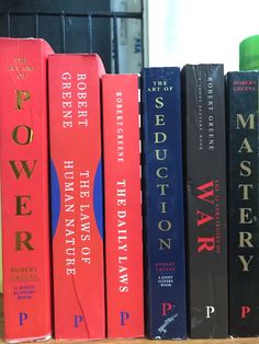 a row of books sitting on top of a wooden shelf