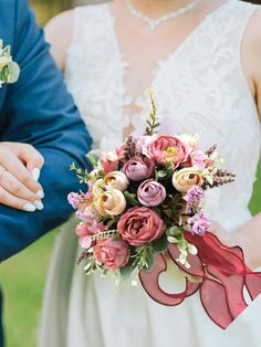 a close up of a person holding a wedding bouquet