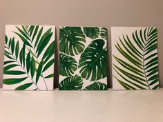 three canvases with green leaves on them sitting on a white counter top next to each other