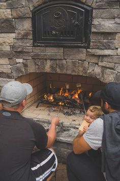 two people sitting in front of a fire place