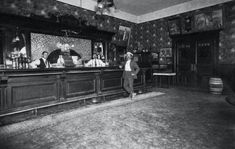 an old black and white photo of men at a bar