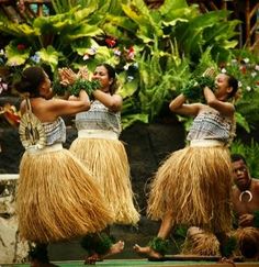 three women in grass skirts dancing on stage