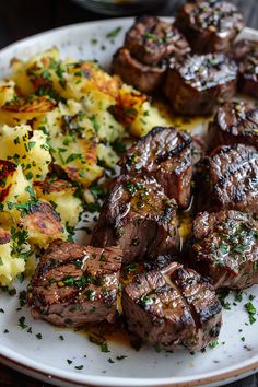 steak, potatoes and carrots on a plate with parsley sprinkled on top