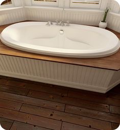 a large white bath tub sitting on top of a wooden counter next to a window