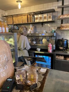 a woman standing behind a counter in a restaurant