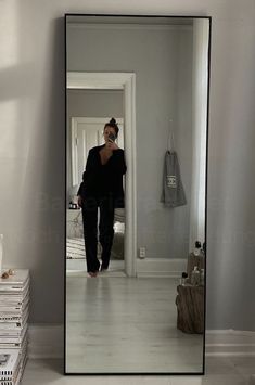 a woman is taking a selfie in the mirror while walking down the hall way