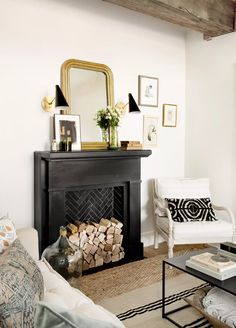 a living room filled with furniture and a fire place next to a mirror on the wall