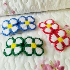 four small flowers are sitting on top of a quilt