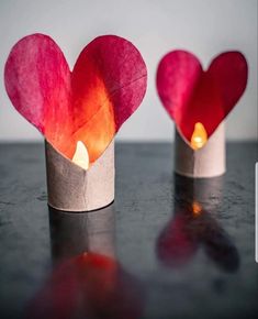 two paper cups with candles in the shape of hearts