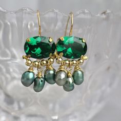 A pair of glowing and dainty earrings set with an oval shaped green zircon in copper bezel. Handmade gold filled beads encircle the lower part of the green zircon, and a trio of beautiful greenish pearls dangle down gently.   The hook is made of gold filled.  This unique design is timeless, so you can enjoy it for years and years to come and pass it on.  Measurements: Green zircon in diameter: 10x14mm Total length including the hook: 3.5cm Materials: Stones: green zircon, pearls Metal: gold fill Green Pearl Earrings For Anniversary, Green Gemstone Pearl Drop Earrings, Green Gemstone Drop Pearl Earrings, Green Dangle Pearl Earrings For Anniversary, Green Pearl Drop Earrings For Anniversary, Green Pearl Drop Earrings For May Birthstone, Green Oval Earrings For Party, Elegant Green Pearl Earrings For May Birthstone, Green Oval Earrings For Anniversary