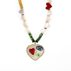 Add a splash of vibrant elegance to your summer wardrobe with the White Pearl Heart Beaded Evil Eye Talisman Necklace. This eye-catching piece features heart-shaped pearl beads interspersed with colorful pearl stones, creating a mesmerizing dance of colors that radiates joy and style. The centerpiece of this necklace is a striking pendant adorned with a red heart and an evil eye, symbols of love and protection. Complementing this unique pendant is an 18k gold-plated heart accent bead positioned near the pendant, adding a touch of luxurious charm right from the beginning of the necklace. Details Pearl heart shape beads Gold color Hematite stone spacers 18K gold plated red enamel bead 18k gold plated Murano glass heart shape pendant Necklace length 30"  Pendant height 1'' width 1'' Avoid con White Beaded Necklace With Heart Charm Pendant, White Beaded Necklace With Heart Pendant, Heart-shaped White Beaded Necklace With Pearl Charm, White Heart-shaped Jewelry For Summer, Trendy Heart-shaped Summer Necklace, Multicolor Beaded Heart Pendant Necklace, Multicolor Heart Beaded Necklaces, Trendy Heart-shaped Multicolor Beaded Necklace, Trendy Multicolor Heart-shaped Beaded Necklace