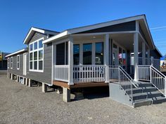 a mobile home with stairs leading up to the front door and second story porch area