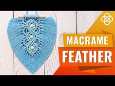 the macrame feather is hanging on a wooden wall next to a piece of yarn