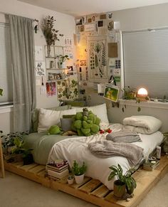 a bed with lots of plants on top of it in a room filled with windows