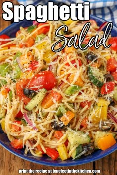 spaghetti salad in a blue bowl on a wooden table with text overlay that reads spaghetti salad