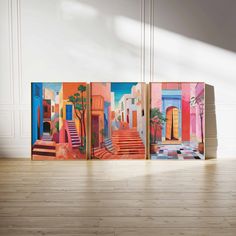 three colorful paintings are on display in an empty room with wood floors and white walls