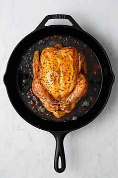 a chicken is cooking in a skillet on the stove top, ready to be cooked