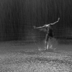 a man standing in the rain with his arms outstretched