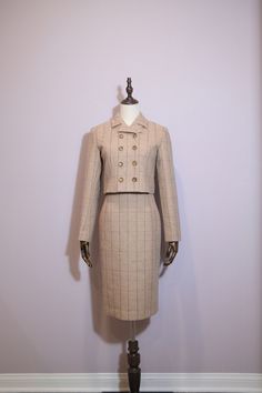 Features: - Elegant beige plaid fabric with subtle lines. - Six decorative buttons in two rows on the jacket. - Cropped jacket for a contemporary twist on a classic style. - High-waisted pencil skirt to elongate and enhance your silhouette. - Perfect balance of vintage charm and modern sophistication. - Versatile style suitable for a variety of occasions. Composition: 80% Wool 20%Polyester Care: Suggested dry clean only to maintain fabric integrity. Beige Plaid, High Waisted Pencil Skirt, Retro Gift, Double Breasted Jacket, Decorative Buttons, Plaid Fabric, Wool Suit, Cropped Jacket, Wool Plaid