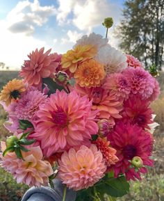 a vase filled with lots of pink and yellow flowers