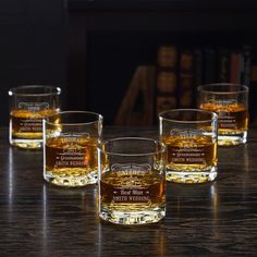 four glasses filled with whiskey sitting on top of a table