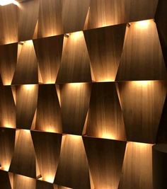 a wall made out of wooden blocks with lights on it and some lighting in the corner