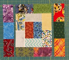 a close up of many different types of fabric on a cutting board with a ruler