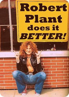 a woman sitting in front of a sign that says robert plant does it better