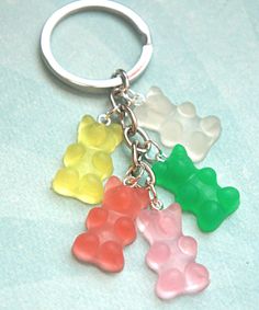 four gummy bears are sitting together on a keychain and one is green, the other is red