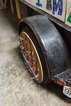 an old tire is sitting on the ground in front of some boxes with writing on them