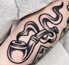 a man's arm with a pipe tattoo on it