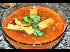 a glass bowl filled with soup and garnished with cilantro