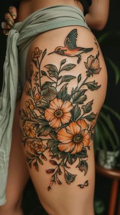 a woman's thigh with flowers and a bird on it